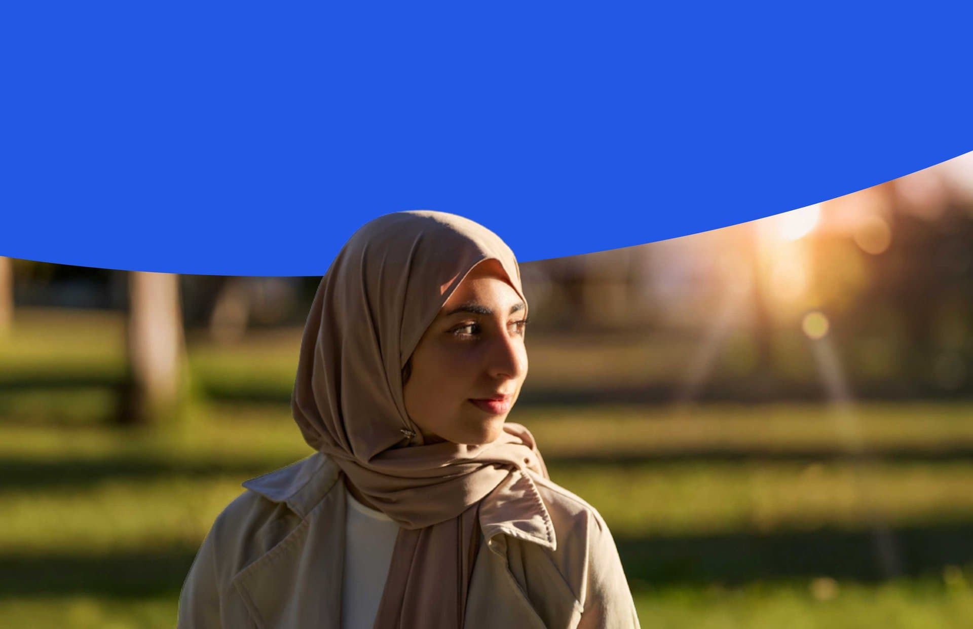Mujer joven con hiyab en un parque al atardecer - Memoria de actividades de Accem 2025